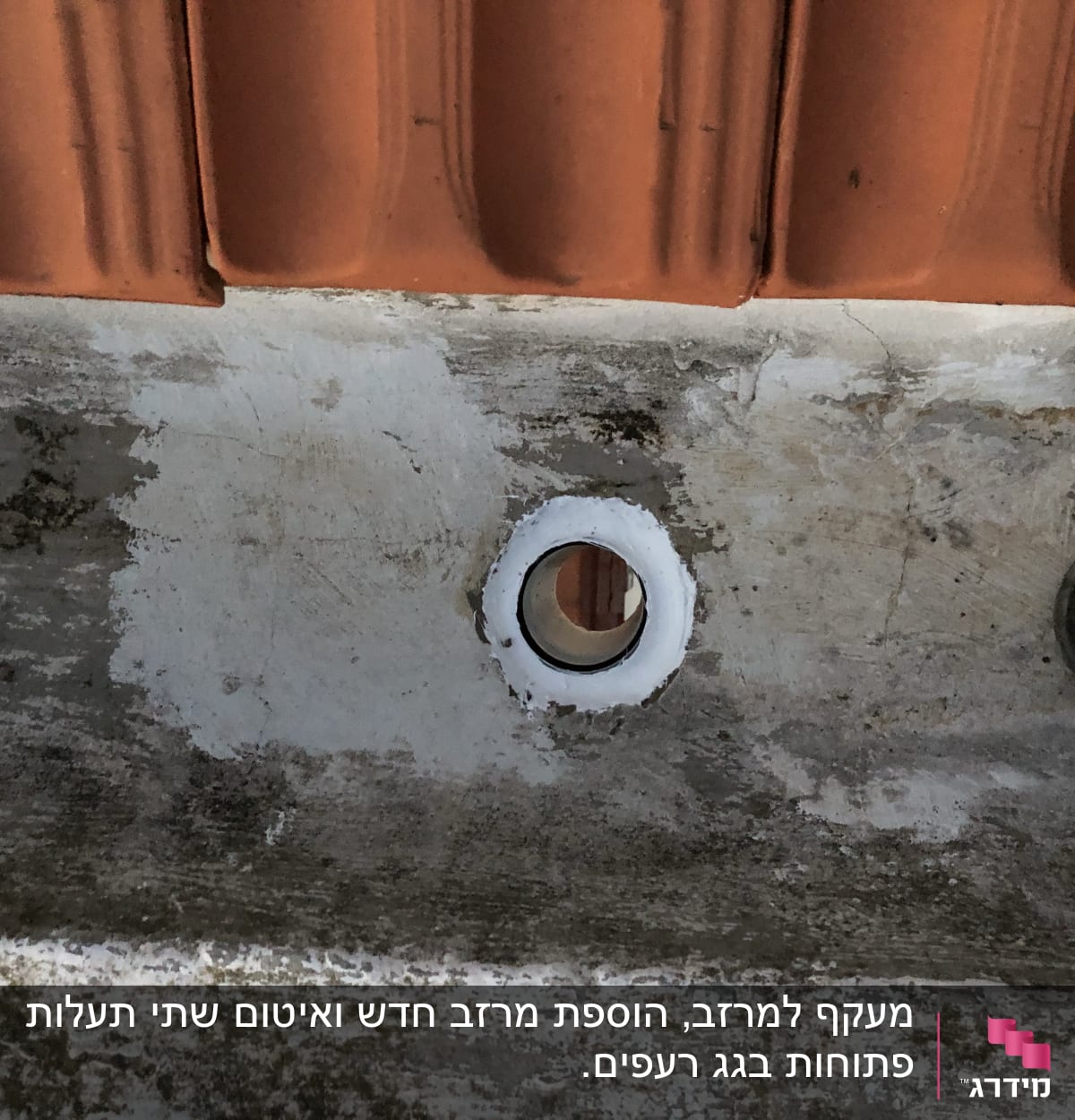 פתח ניקוז בגג עם רעפים כתומים